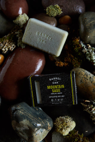 Barrel Oak Mountain Sage soap bar on a stone surface with rocks and moss.