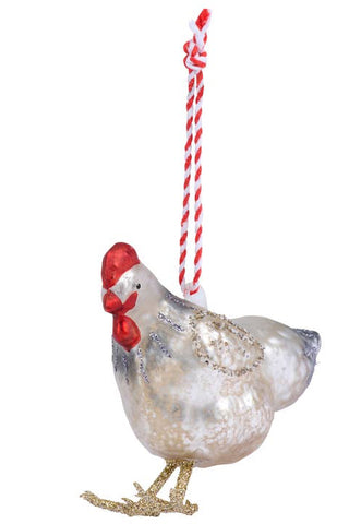 A decorative chicken ornament with a glittery white body, red comb and wattle, and gold feet, hanging from a red-and-white striped string on a plain white background.