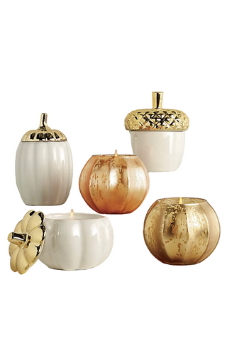 Five decorative candles in pumpkin and acorn shapes with glossy white and metallic gold finishes, arranged on a plain white background.