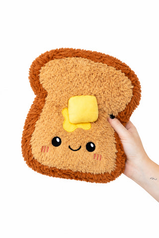 A plush toy shaped like a slice of toasted bread with a yellow butter patch.
