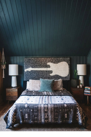 An art print featuring a white guitar with black text that includes lyrics and quotes from various musicians.