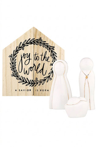 Wooden sign with 'joy to the world' and 'a savior is born' text, accompanied by white angel figurines on a white background.