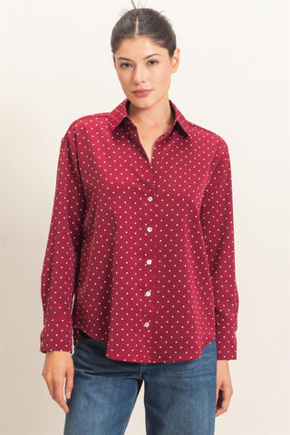 Woman wearing a red patterned shirt and blue jeans on a beige background