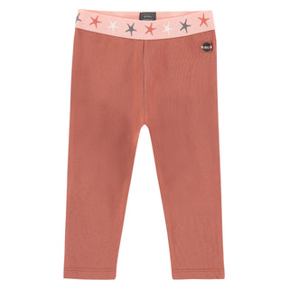A pair of orange pink leggings for girls, with a starfish pattern on the elastic waistband.
