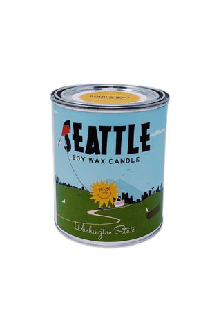 A tin candle with a label featuring a sun and greenery, indicating a connection to Seattle, with the text 'Seattle Soy Wax Candle' and 'Good & Well Supply Co.'.