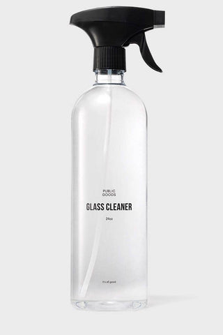 A clear spray bottle labeled 'GLASS CLEANER', indicating that it is used for cleaning glass surfaces.